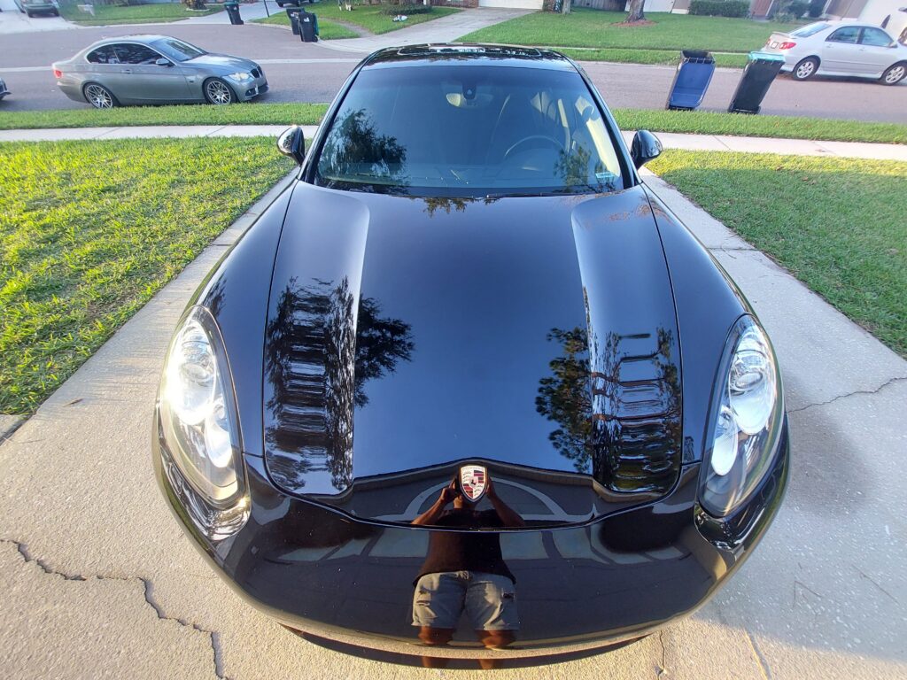 reflection of the hood of a black Porsche panamera after paint correction in Waterford lakes, FL